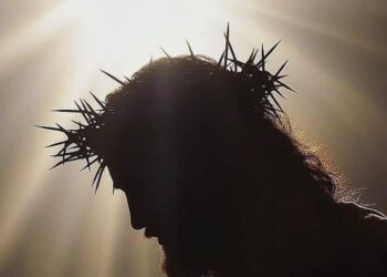Silhouette of Jesus Christ with crown of thorns and radiant light symbolizing His sacrifice and resurrection, representing the true meaning of Easter in 2025