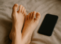 Digital illustration of feet near a smartphone, representing selling feet pictures online for money
